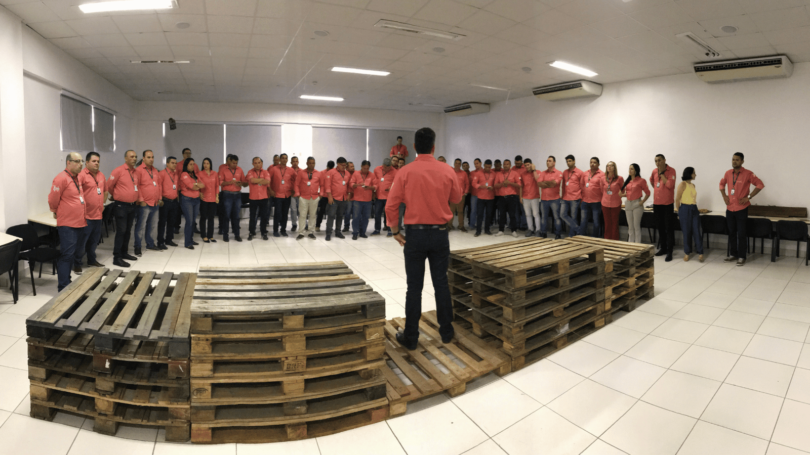 Instrutor de merchandising dando treinamento de merchandising teórico e prático para equipe de supervisdores
